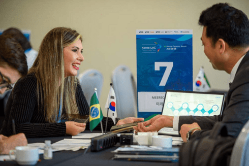 Women smiling in front of a men in office - Inter American Development Bank - IDB Trade
